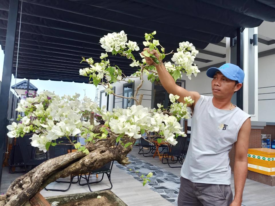 Anh Nguyễn Đức Hòa trong ngôi nhà mới khang trang tại khu tái dịnh cư Lộc An - Bình Sơn đang chăm sóc gốc hoa chuẩn bị đón Tết.