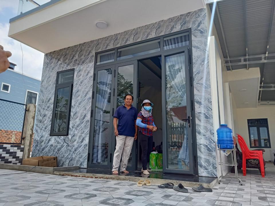 Gia đình anh Tạ Kế Tuấn phấn khởi bên căn nhà mới xây dựng xong tại khu tái định cư Lộc An - Bình Sơn.